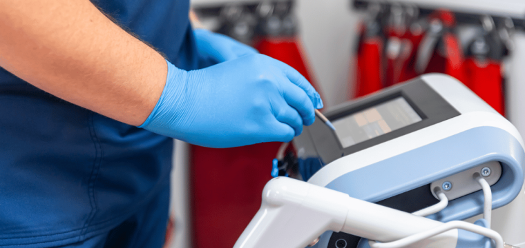 Healthcare professional preparing a focused shockwave therapy device during treatment for Peyronie's disease.