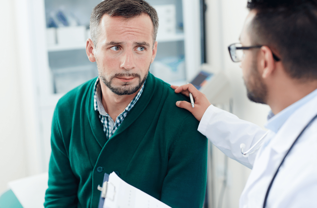 Doctor discussing Peyronie's disease treatment options with a patient during a medical consultation.